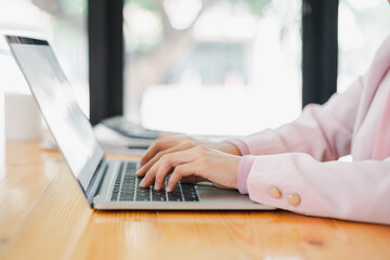 Fototapeta premium Cropped shot of businesswoman working,typing on tablet computer. Selective focus,Soft focus.