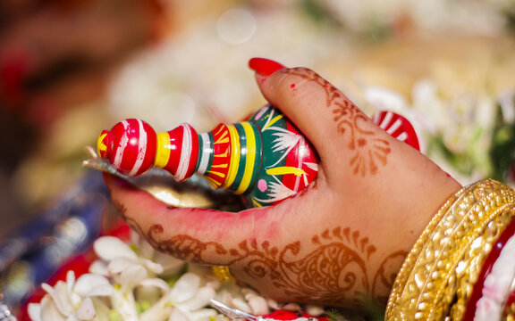 Bengali bride hand holding a colorful thing called gachkouto with beautiful background