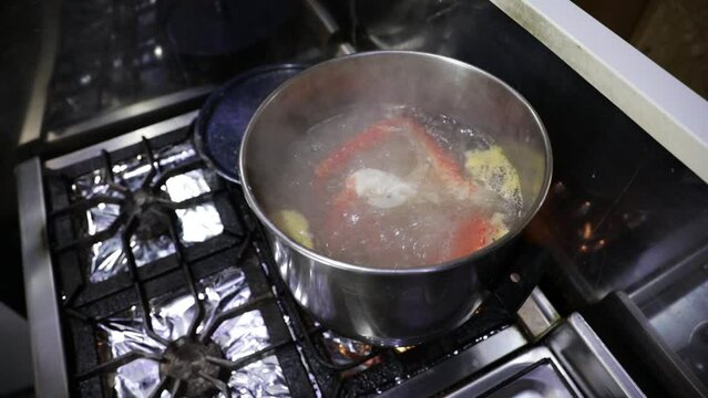 Red King Crab legs with boiling water in the cooking pan in the restaurant kitchen. 
