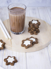 Chocolate cookies and a glass of cacao. Chocolate dessert. Sweet breakfast. Coffee with milk. Coffee and cookies. Breakfast for kid. Stars cookies. Star shaped cookies. 