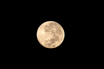 View of a full moon in a cloudless, clear sky.
