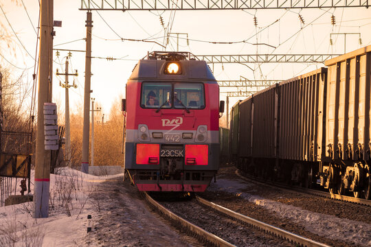 SHARYA, RUSSIA - MARCH 19, 2021: Russian electric locomotive 2ES5K "Ermak" and a oncoming freight train on a turn on  March sunny evening. Northern railway