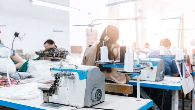 Concept Interior of garment factory. Closeup spool of multicolored threads for sewing machine