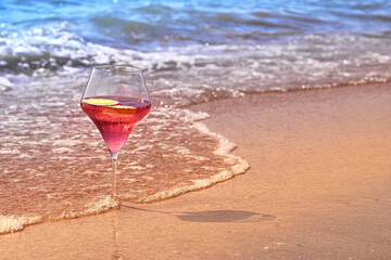 Wine glass with a cocktail by the sea.