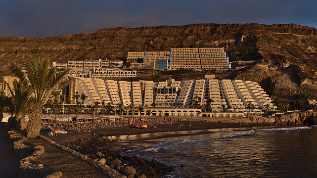 Beautiful panoramic view over the sand beach of holiday resort Taurito, Gran Canaria, Spain on the Atlantic coast with palm trees and huge hotels.