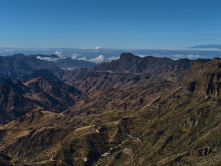 Beautiful aerial view of the western mountains of island Gran Canaria, Canary Islands, Spain on sunny day in winter seaon with winding country road.