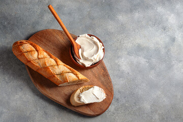 toasted sliced garlic bread baguette with cottage cheese served on cutting board with blue linen napkin on gray stone background. bakery concept..