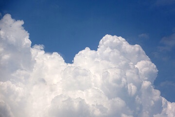 Naklejka na ściany i meble Thick white clouds against a blue sky background 