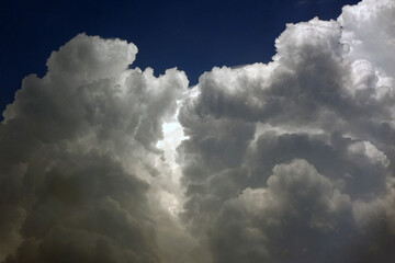 Thick white clouds against a blue sky background       