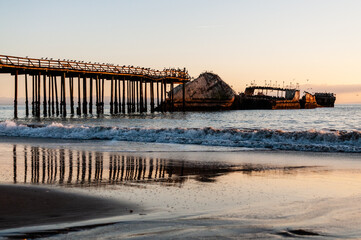 A beautiful sunset over the beach near Aptos, California, highlighting the old derelict pier and an...