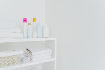 Stack of white soft towels with soft conditioner liquid. White background with copy space for your information. Cleanliness concept