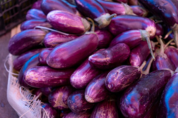 Eggplants at a food market in the Dominican Republic. Highly saturated purple and orange vegetables, food photography background.