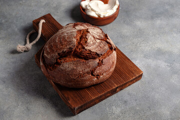 loaf of artisan dark unleavened bread with cottage cheese searved on cutting board
