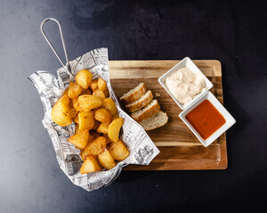 Presentación de ración de la típica tapa española, las patatas bravas, con pan, salsa de alioli...