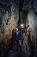 Young woman exploring a cave digged in the mountain.