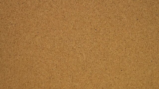 Fake news. Stick the sticker on the cork board. Top view of note board. Wall of records in the office. Leave a reminder at work or at home. Caucasian male hand sticks and unsticks paper.