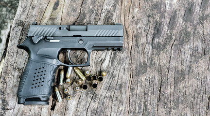 Obraz premium 9mm automatic pistol and bullets on wooden table, soft and selective focus on pistol, copy space.