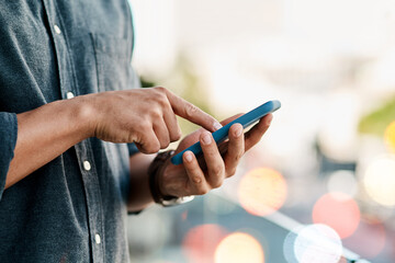 Staying connected keeps business moving. Cropped shot of a businessman using a smartphone against a city background.