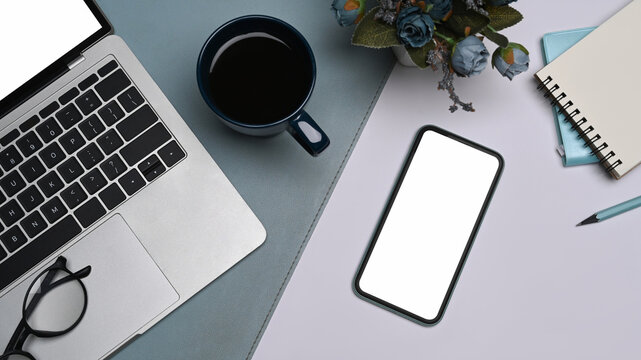 Mobile Phone With Blank Screen, Laptop Computer, Coffee Cup And Notebook On White Table. Flay Lay.