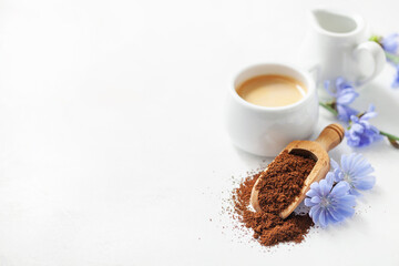 Diet drink chicory in a cup - coffee substitutes, powder and flowers on the white background.