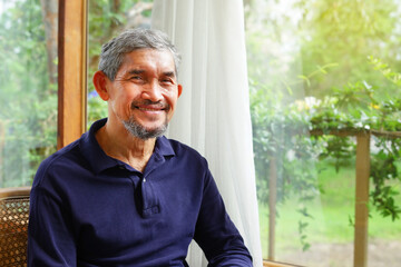 portrait senior man relaxing in the house, background nature atmosphere by glasses window, concept...