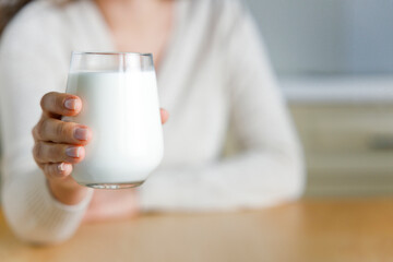 Fototapeta na wymiar Young woman holding a glass of milk.
