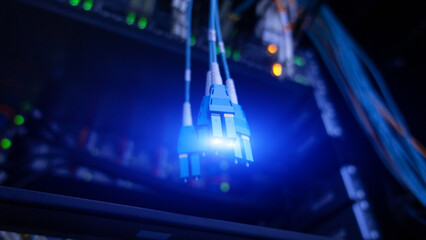 Fiber optic and hub in dark server room.