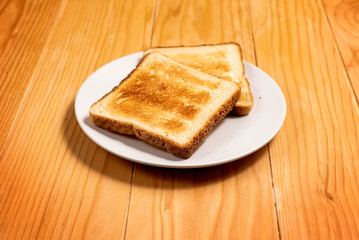 Two Slices of Toast Bread on a Wooden Table Setup - Selective Focus