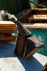 Equipment for smoking bees to keep them calm. Beekeeping. The beekeeper uses a smoking metal container that creates dense smoke