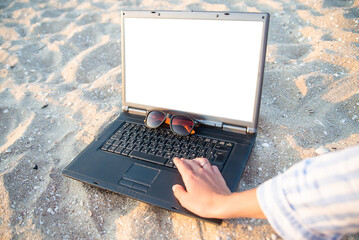 laptop on the beach in the sand. glasses against the sun. rest