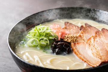 湯気が上がる、シズル感のある豚骨ラーメン