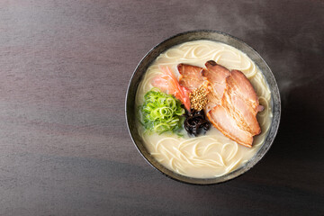 湯気が上がる、シズル感のある豚骨ラーメン