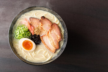 湯気が上がる、シズル感のある豚骨ラーメン