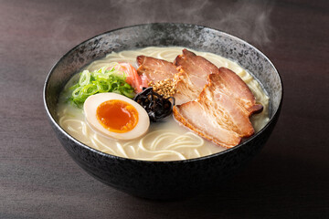 湯気が上がる、シズル感のある豚骨ラーメン