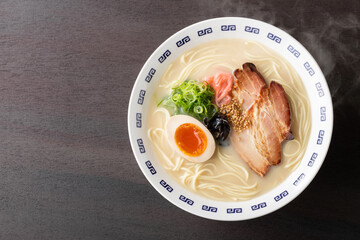湯気が上がる、シズル感のある豚骨ラーメン