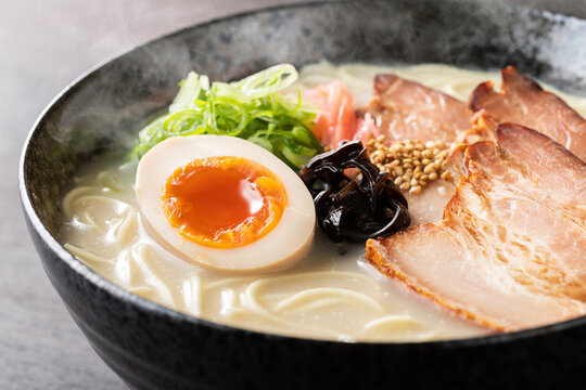 湯気が上がる、シズル感のある豚骨ラーメン