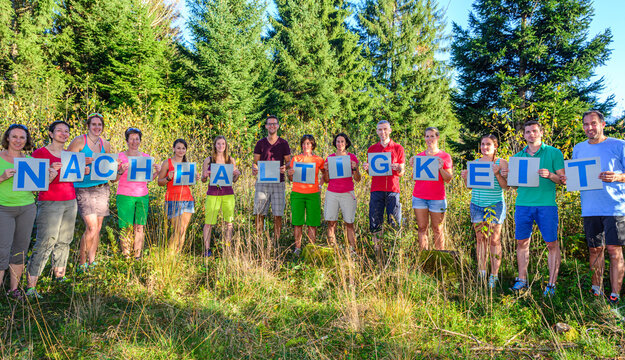 Gruppe formt bei einem Coaching-Seminar mit Einzelbuchstaben einen aktuellen Begriff - das Wort Nachhaltigkeit