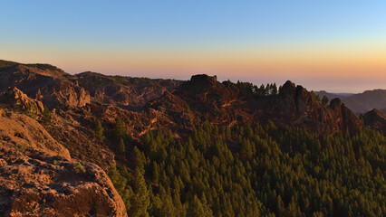 Beautiful panoramic view of the rugged mountains of island Gran Canaria, Canary Islands, Spain at sunset with colorful Belt of Venus in the sky.