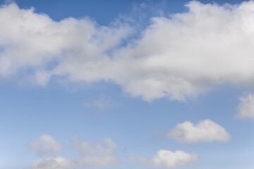 Cumulus and cirrus white clouds on a blue sky background