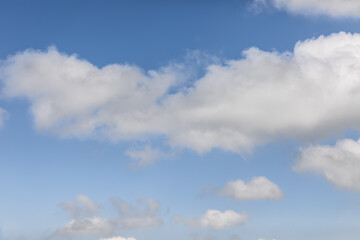 Serene and tousled cumulus clouds on a blue morning sky background