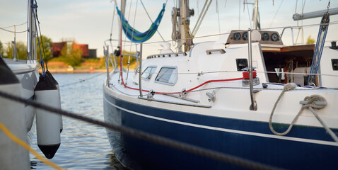 Liveaboard sailboat moored to a pier in a yacht marina on a clear summer day. Private vessel for rent, transportation, recreation, vacations, leisure activity, sport, cruise, lifestyle