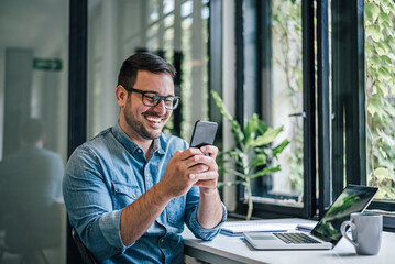 Smiling caucasian man, getting a surprising message on his phone.