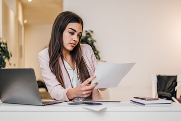Hardworking young woman, checking the company budget.