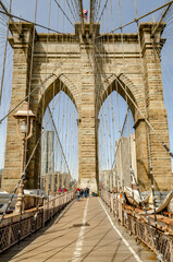 People walking on Brooklyn Bridge during daytime in winter, New York City, construction area on the left and right side on the bridge, vertical