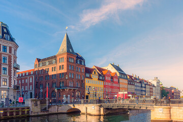 Nyhavn bridge across a canal with old ships, colorful houses and an old Sømandskirken church in Copenhagen, Denmark