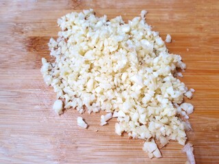 Top view of Chopped garlic on wooden table as a background for sale in the market, ready to cooking (Allium sativum), healthy food concept