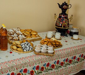 tea table with pies and samovar on a Russian tablecloth