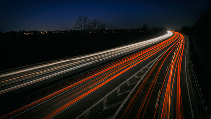 Autobahn bei Nacht mit Lichtspuren mit Verkher von vielen Autos
