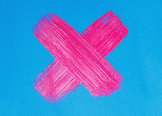neon pink paint brush stroke cross on blue paper