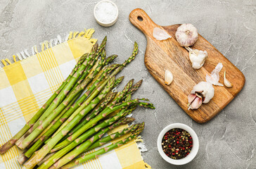 Fototapeta na wymiar Fresh green asparagus cooking on gray background. Top view